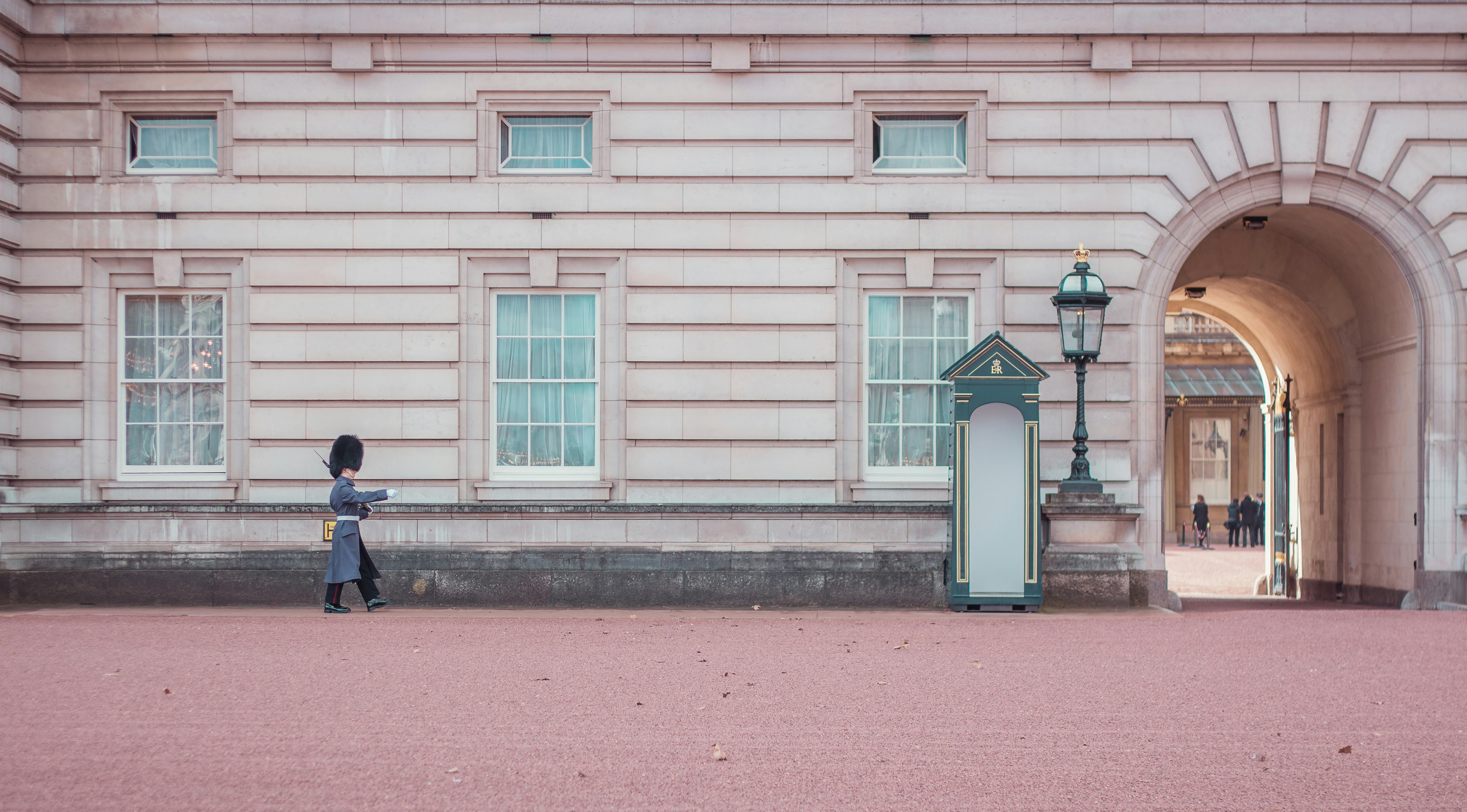 person walking beside beige and gray house